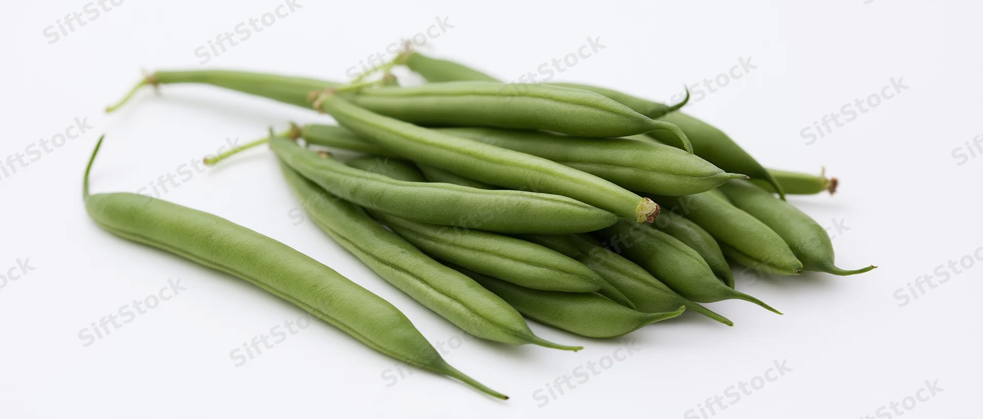 Fresh green beans piled on white surface with one lying flat to the left