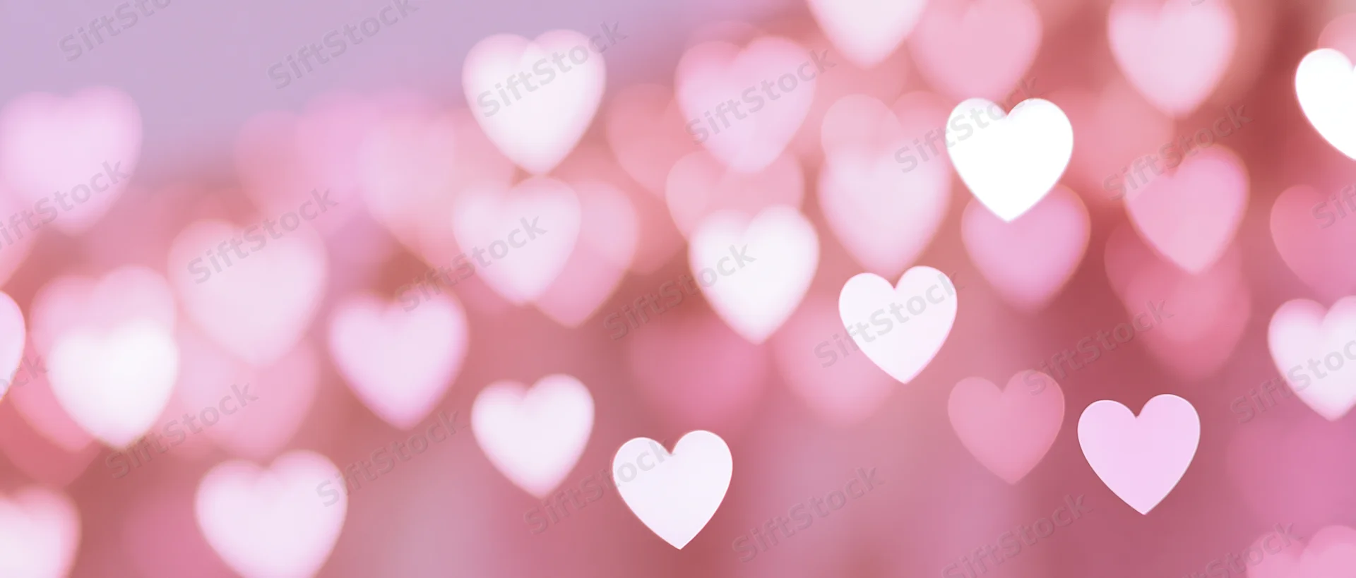 Soft blurred heart-shaped bokeh lights in pink tones as a romantic background