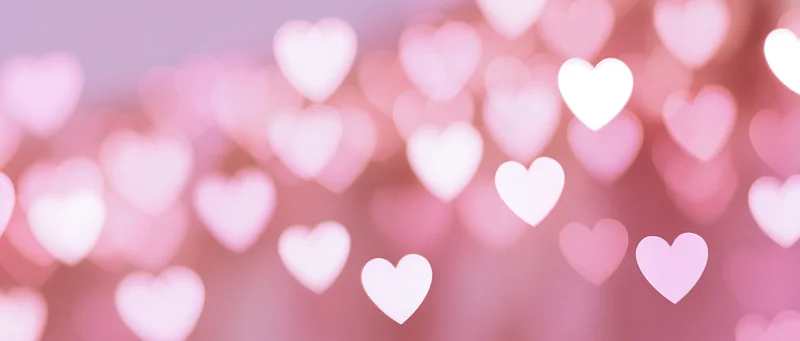 Soft blurred heart-shaped bokeh lights in pink tones as a romantic background