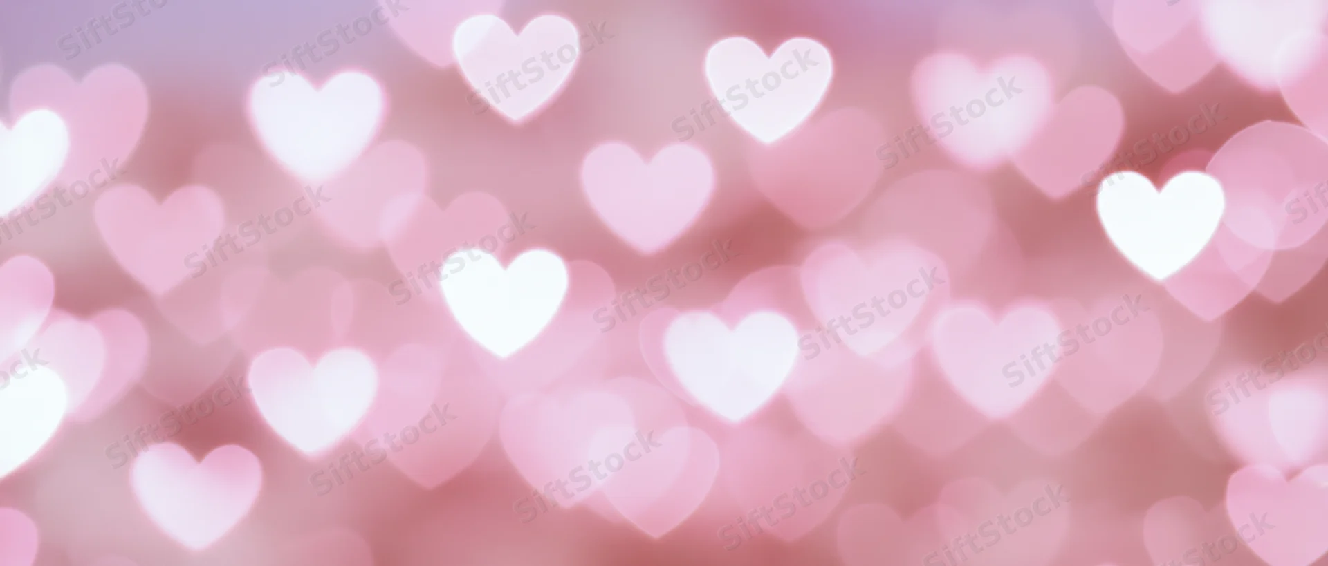 Soft abstract background of blurred heart-shaped bokeh lights in pink and white
