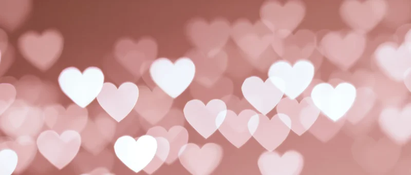 Soft bokeh background with out-of-focus heart shapes in pink and white