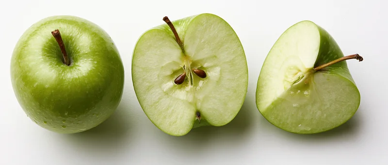 Three green apples in a row, one whole, one halved, one quartered, on a white surface