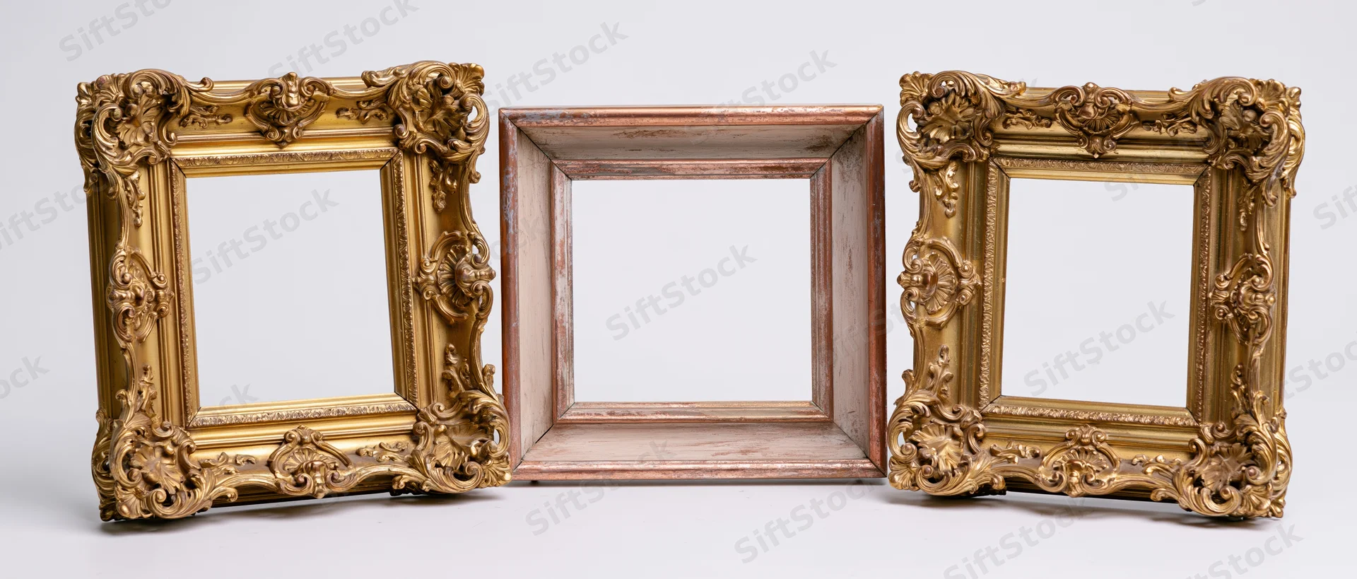 Three antique ornate gold and wooden picture frames arranged side by side on white background
