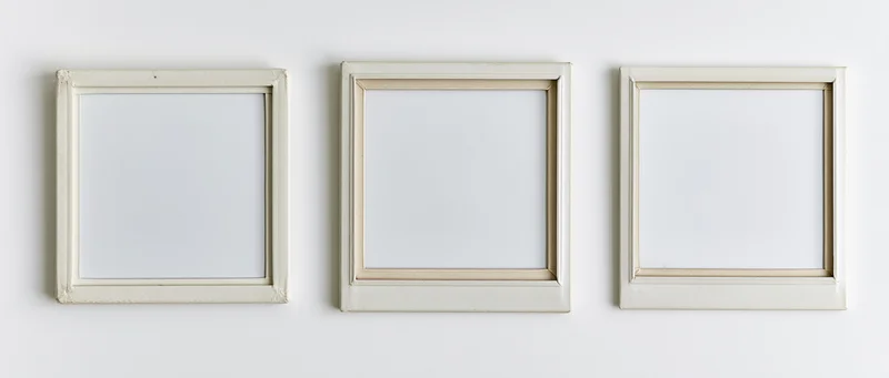 Three blank instant film photo frames arranged horizontally on a white surface