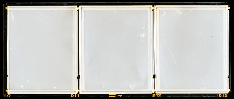 Three blank overexposed medium format film frames arranged in a row on a contact sheet