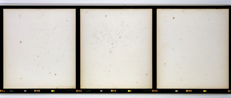 Three blank overexposed medium format film frames arranged horizontally on a contact strip with numbered labels and black borders