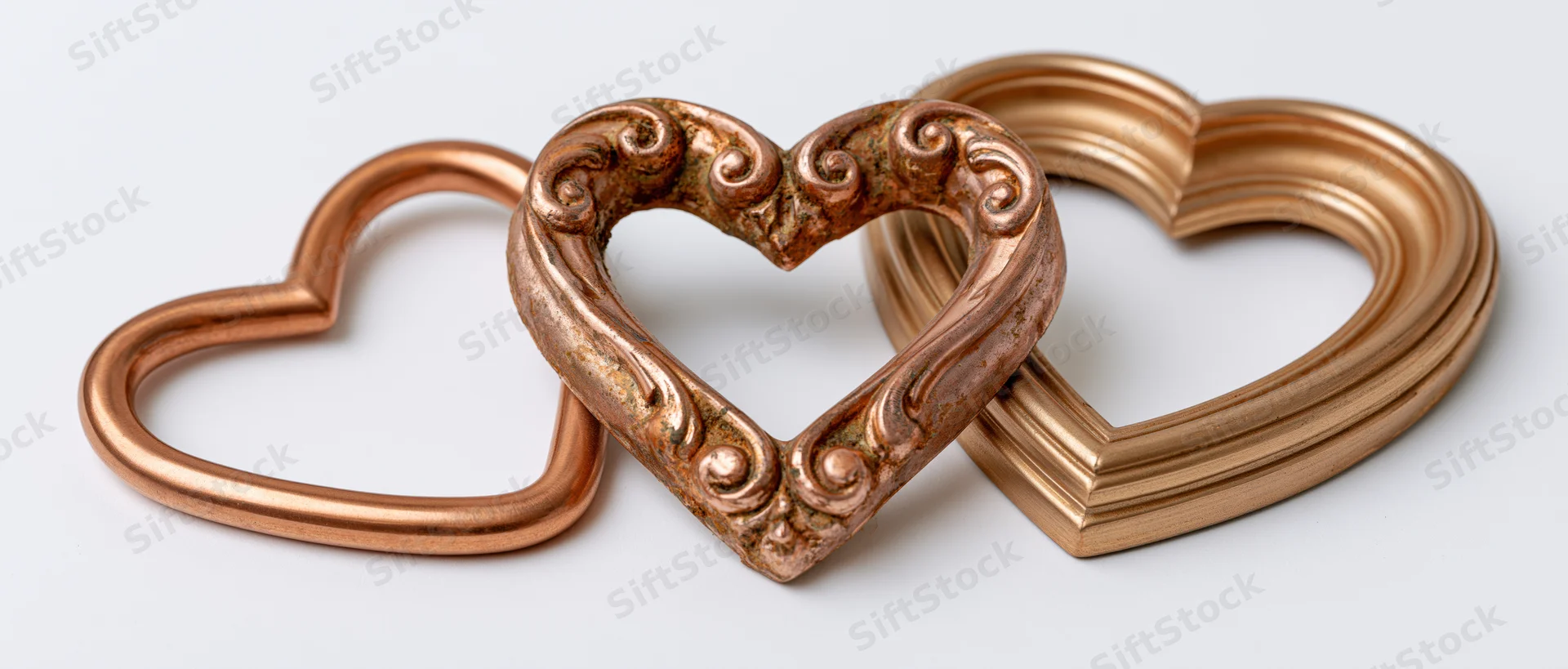 Three heart-shaped decorative frames arranged side by side on a white surface