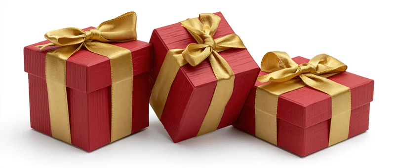 Three red gift boxes with gold satin ribbons and bows arranged on white background