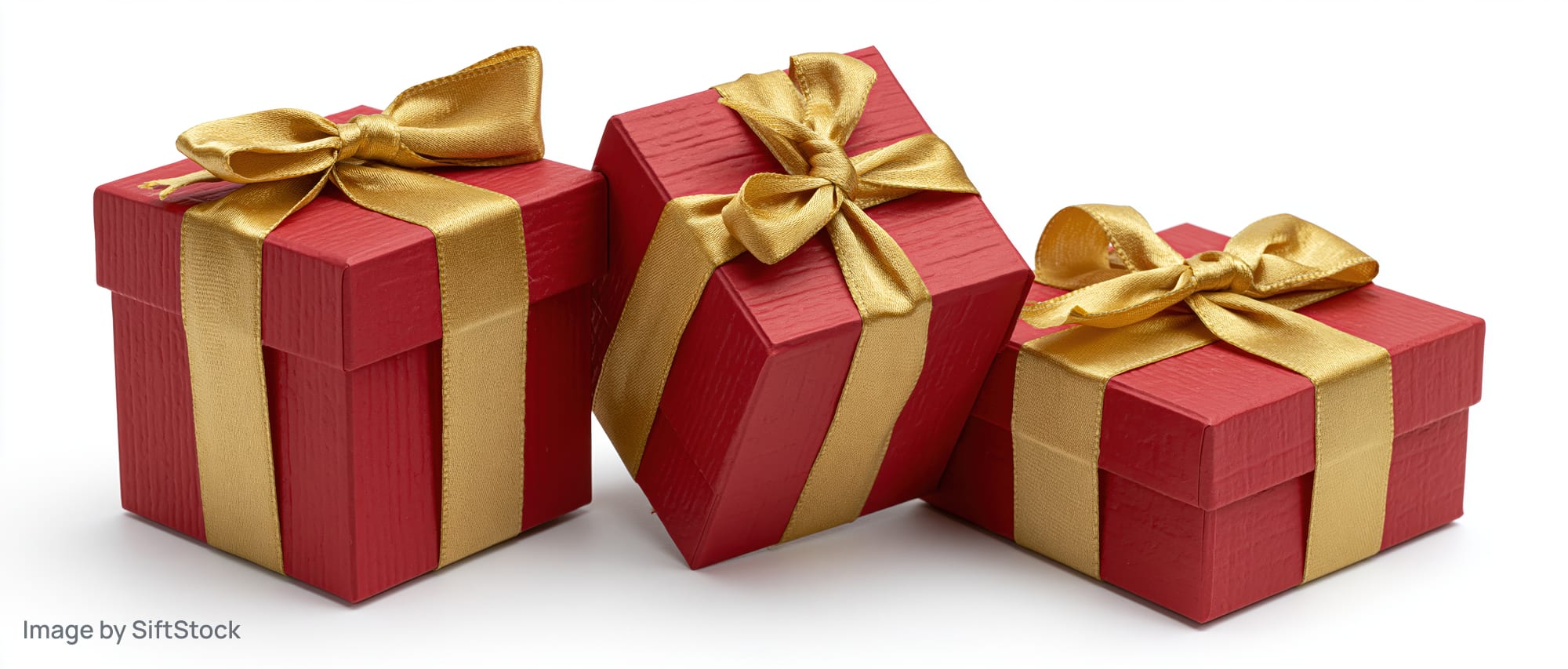 Three red gift boxes with gold satin ribbons and bows arranged on white background