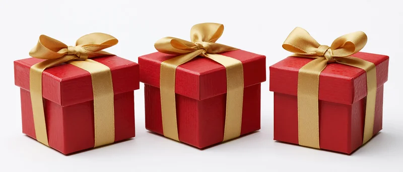 Three red gift boxes with gold satin ribbons and bows arranged in a row on white background