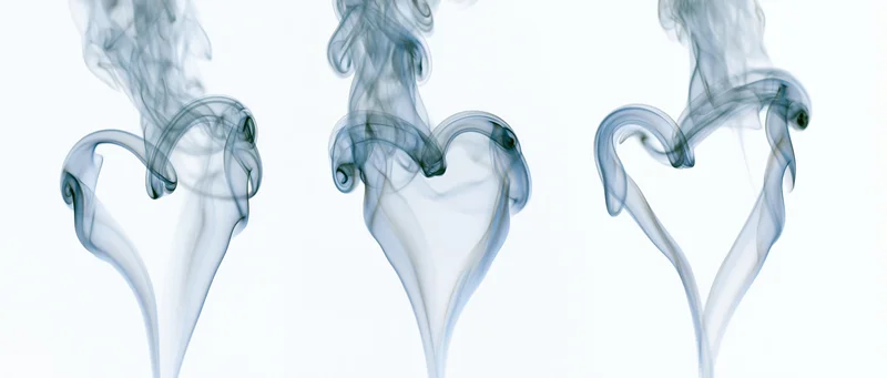 Three smoke plumes curling into heart shapes against a white background
