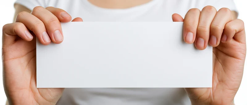 Hands holding a blank white card in front of the body