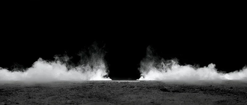 White smoke rising in two columns from a rough ground surface against a black background