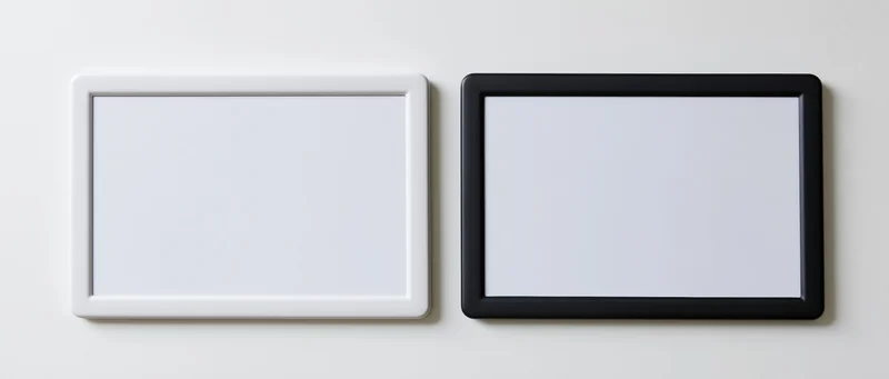 Two tablets with blank white screens mounted side by side on a wall
