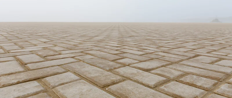 Vast empty public plaza paved with uniform concrete brick pavement under overcast sky