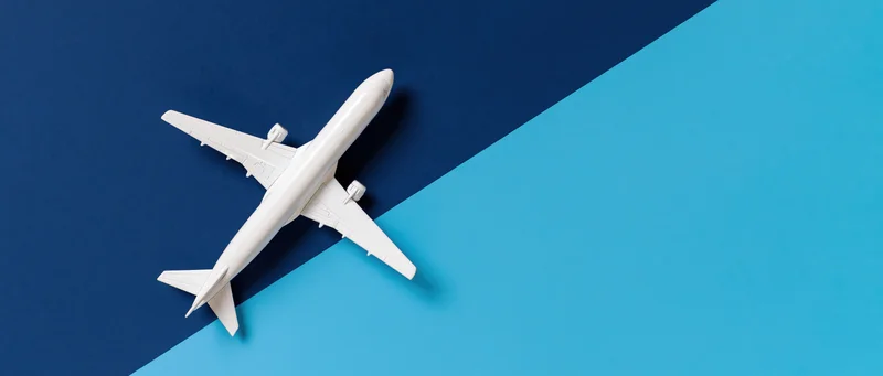 White commercial airplane model viewed from above on blue background