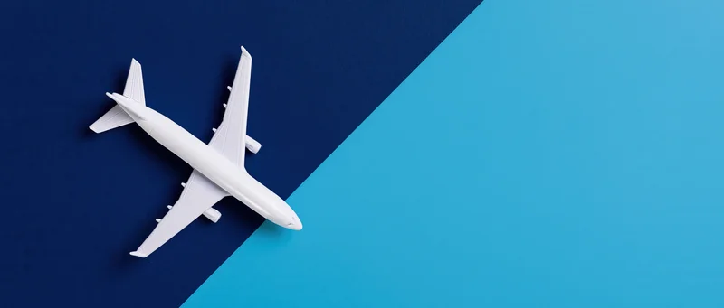 White commercial airplane model viewed from above on blue background