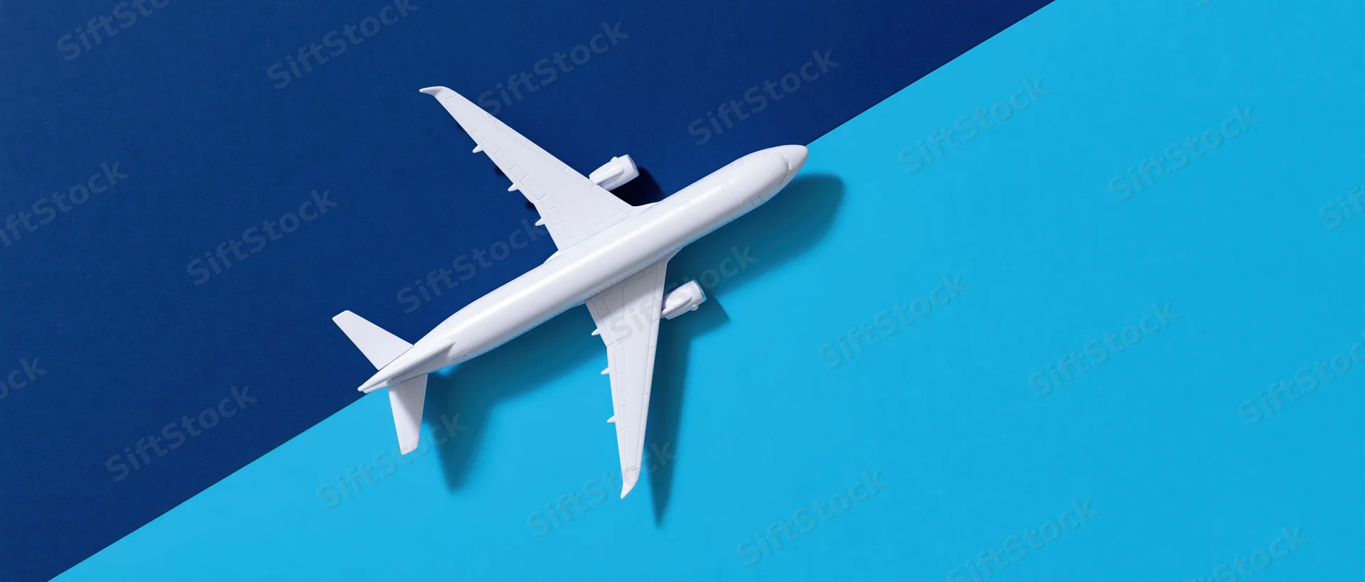 White commercial airplane model on blue gradient background