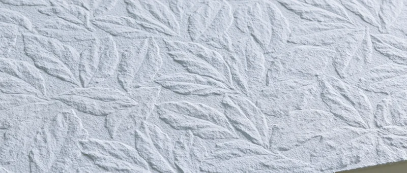 Embossed white wall panel with repeating overlapping leaf pattern
