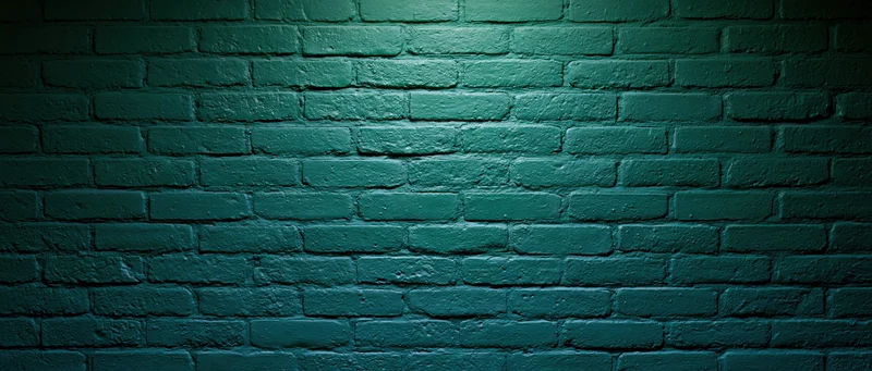 Painted brick wall illuminated by spotlight creating shadows and texture