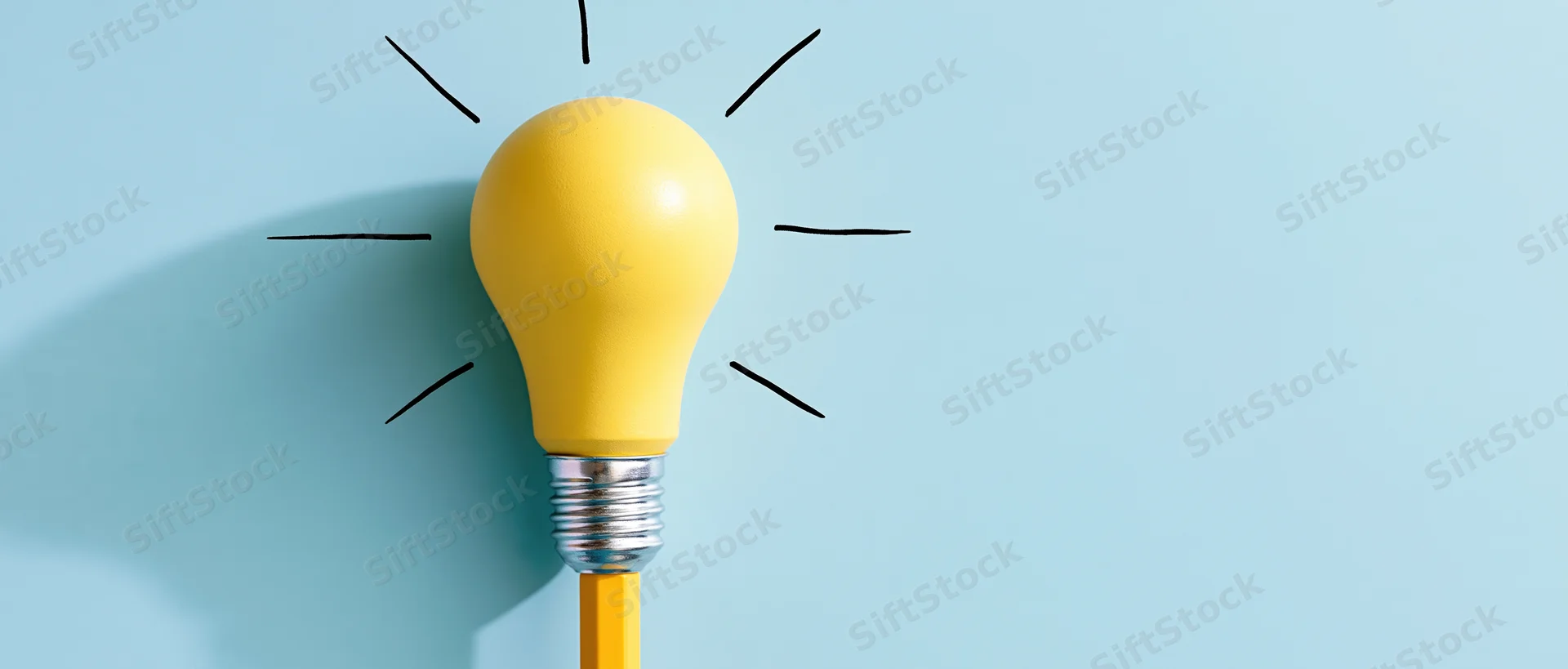 Yellow lightbulb resting on a yellow pencil against a blue background