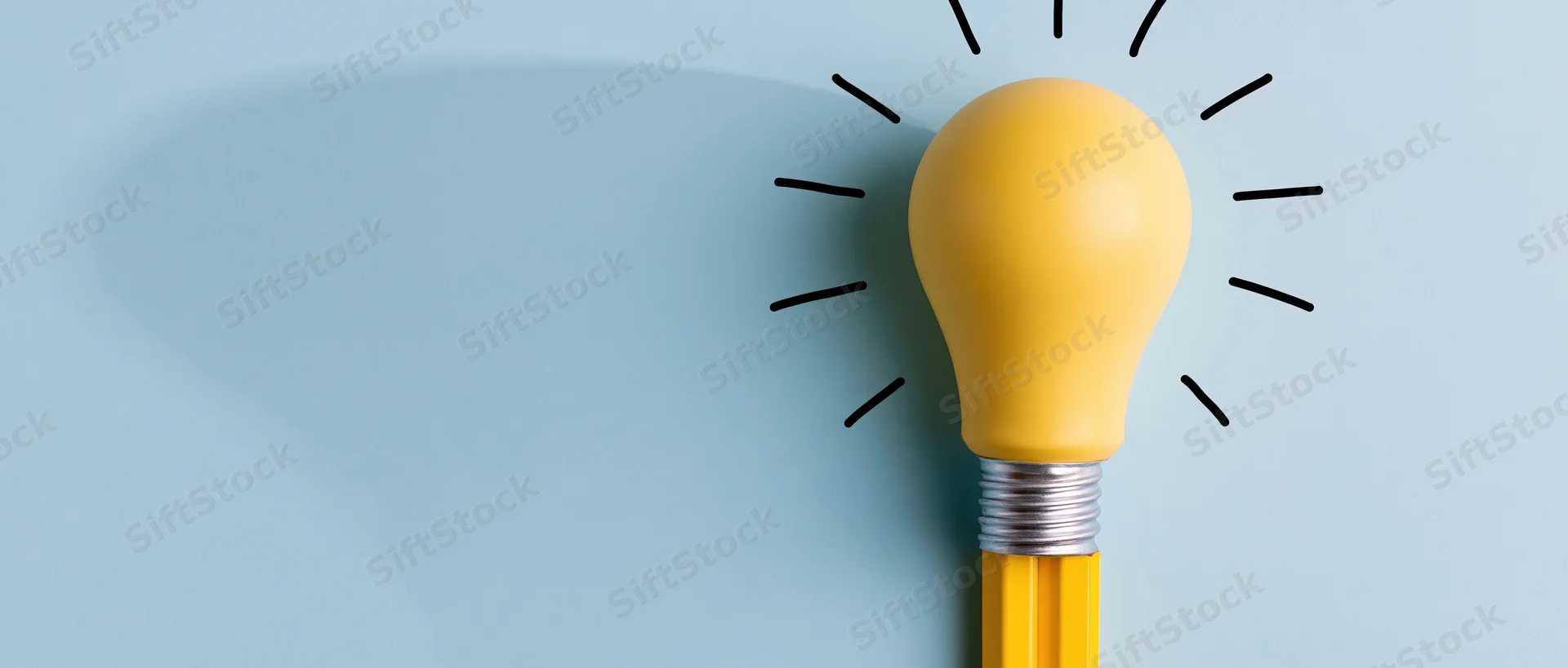 Yellow lightbulb shaped pencil tip with radiating lines on blue surface