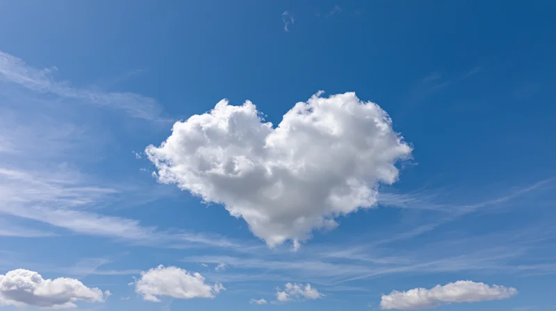 Heart-shaped cloud floating in a clear blue sky