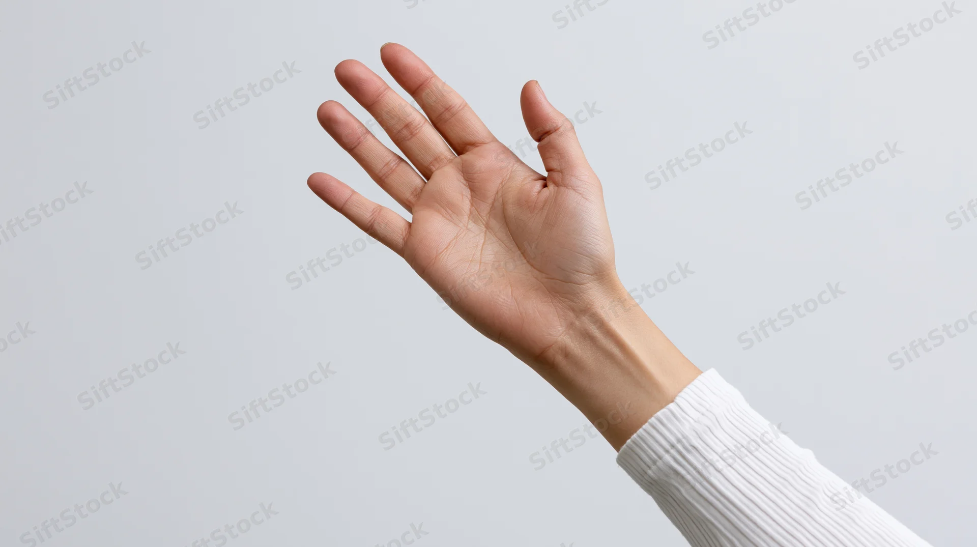 Hand raised upward with palm facing forward against light neutral background