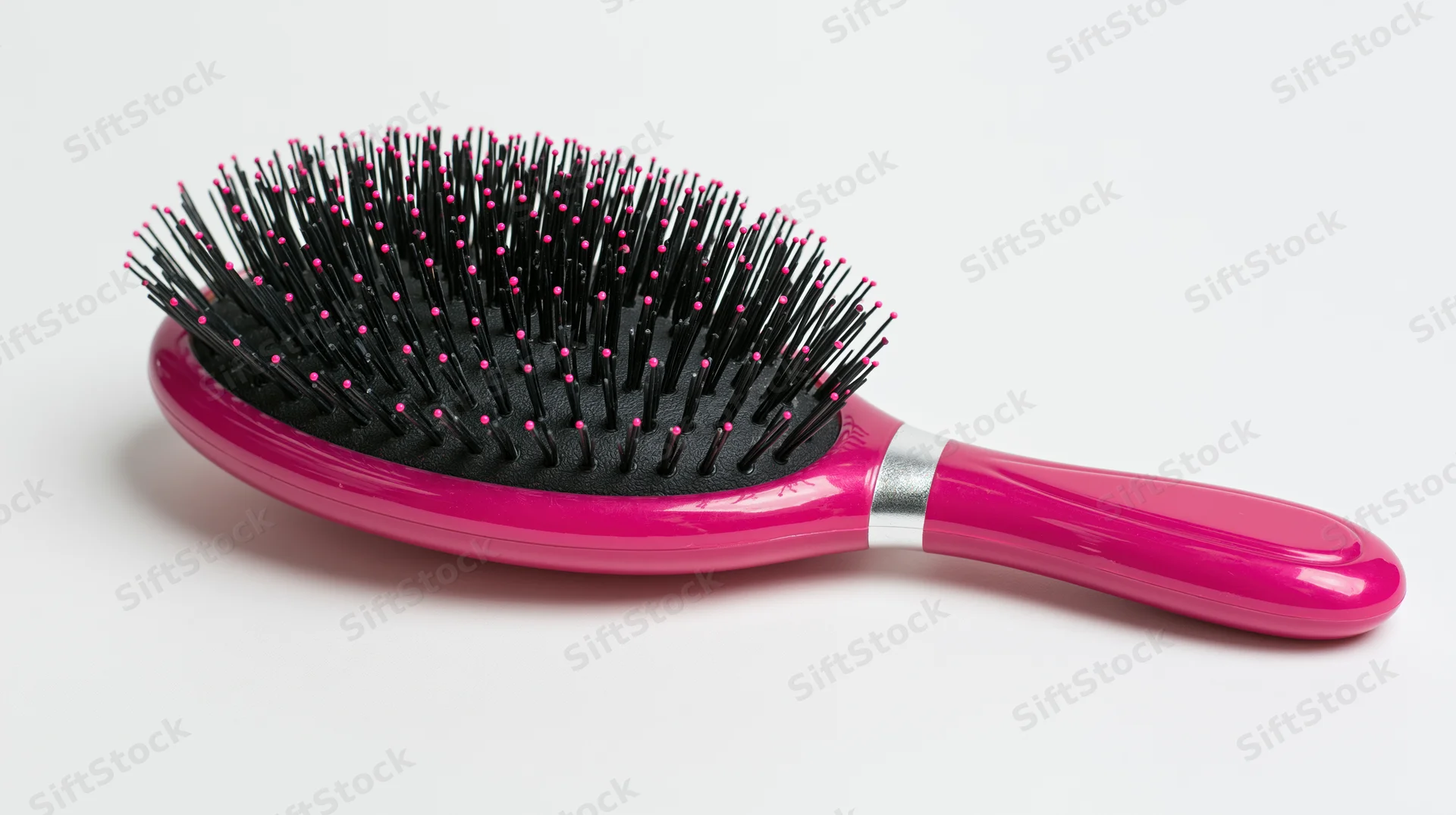 Pink oval paddle hairbrush with black rubber bristles on white background