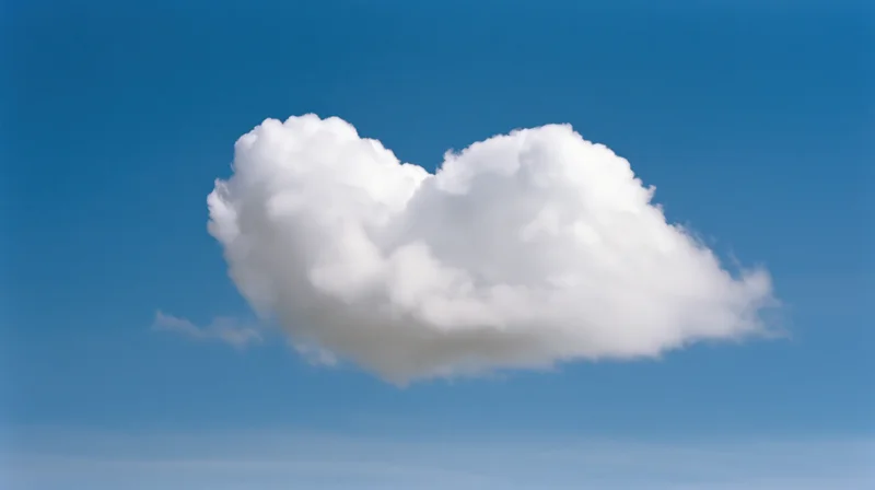 Heart-shaped cloud floating in a clear blue sky