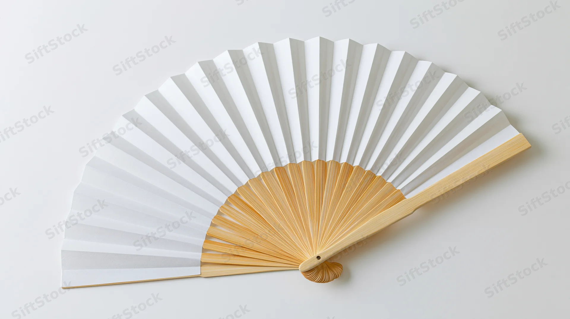 Traditional japanese folding fan fully open lying flat on white surface