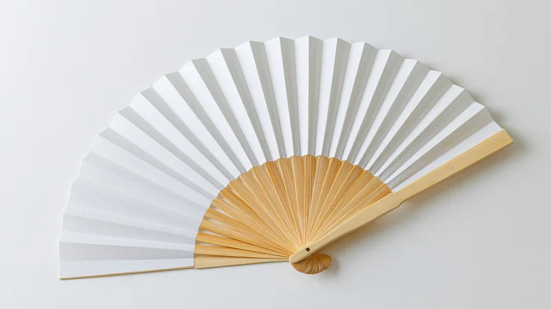 Traditional japanese folding fan fully open lying flat on white surface