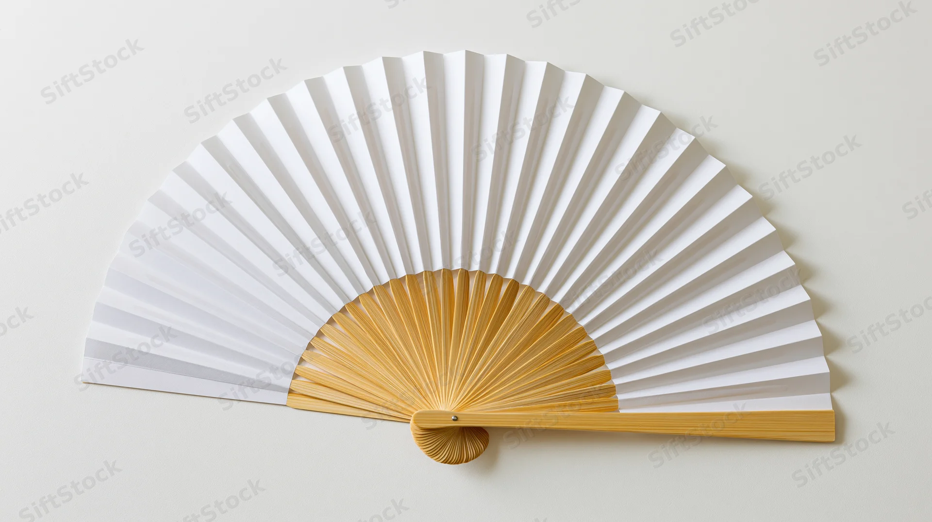 Traditional japanese folding fan fully open lying flat on a neutral surface