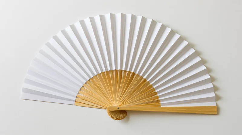 Traditional japanese folding fan fully open lying flat on a neutral surface