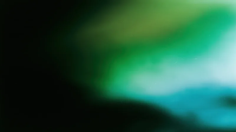 Abstract blurred gradient of green and blue hues transitioning across the frame