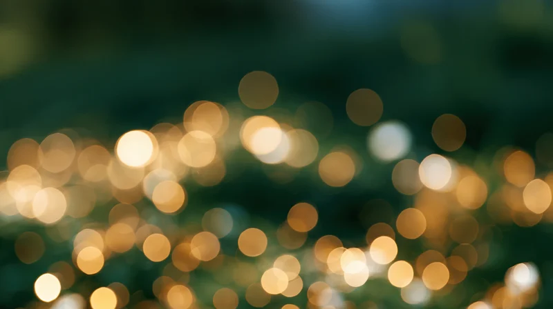 Blurred golden and white lights scattered across a dark background creating a festive bokeh effect