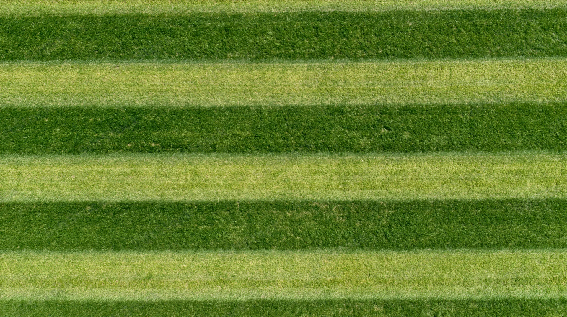 Aerial top-down view of a freshly mowed striped grass sports field