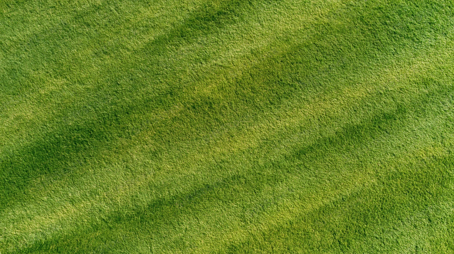 Aerial top-down view of a freshly mowed sports field with striped grass pattern