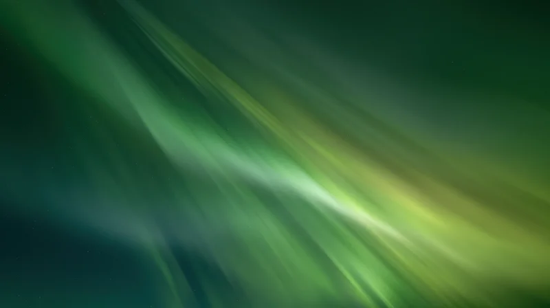 Aurora borealis glowing across dark sky over open tundra