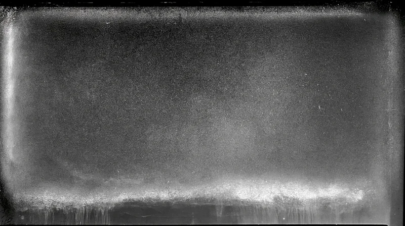 Overexposed film frame with heavy grain and light leaks along the edges
