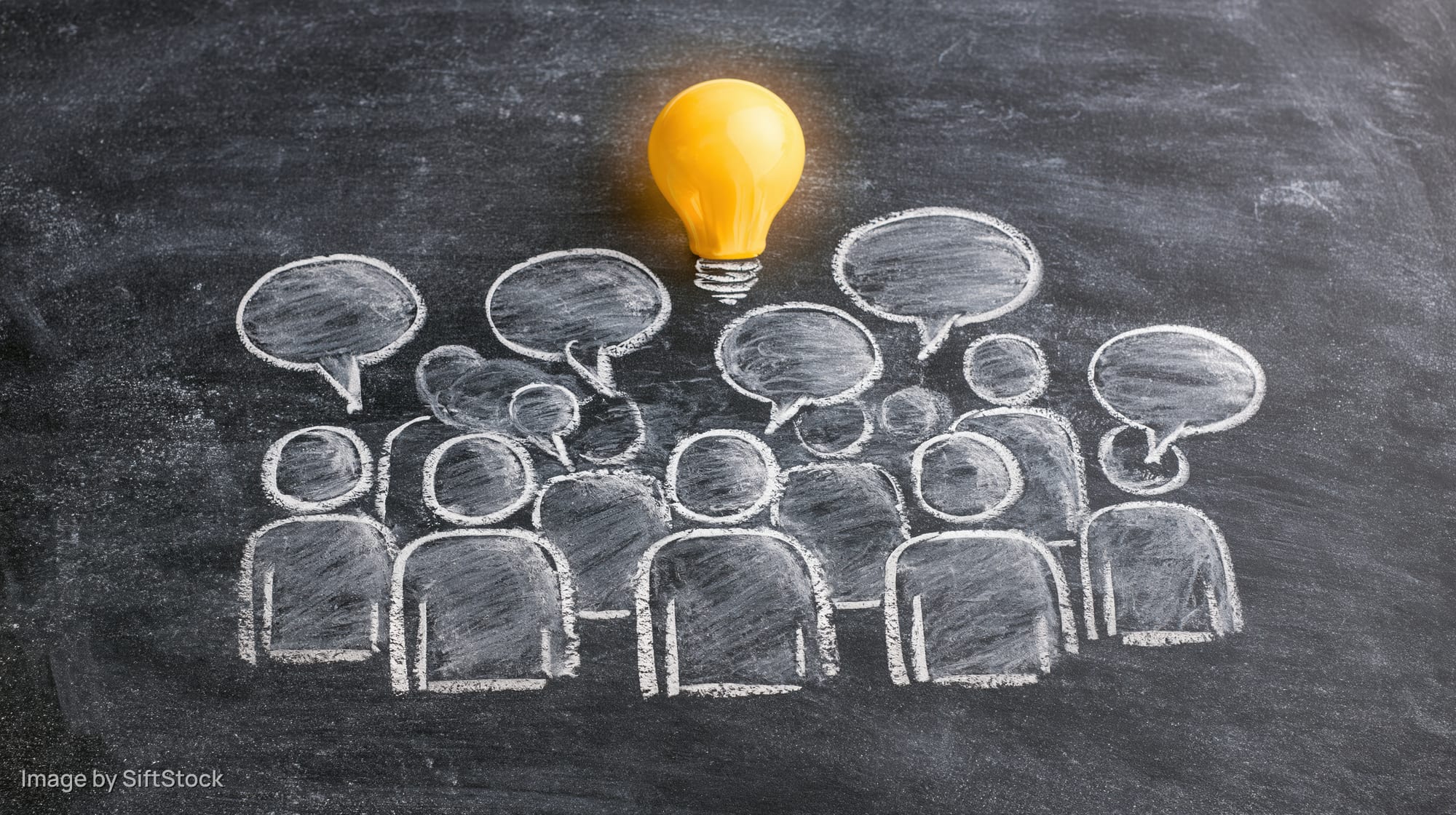 Chalk drawing of a group of people with speech bubbles and a glowing lightbulb on a blackboard