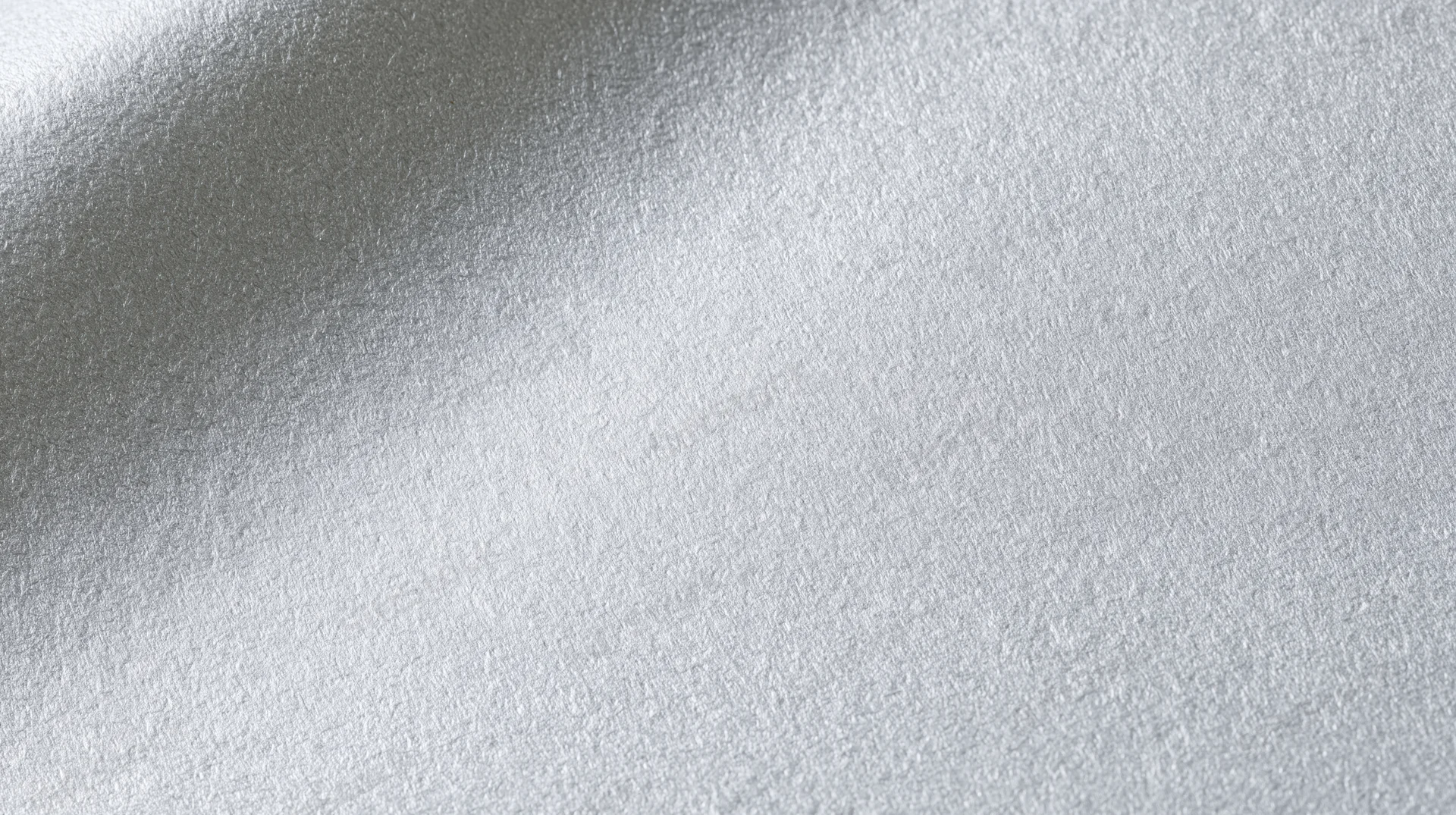Close-up of brushed aluminum surface with frosted texture and subtle light gradient