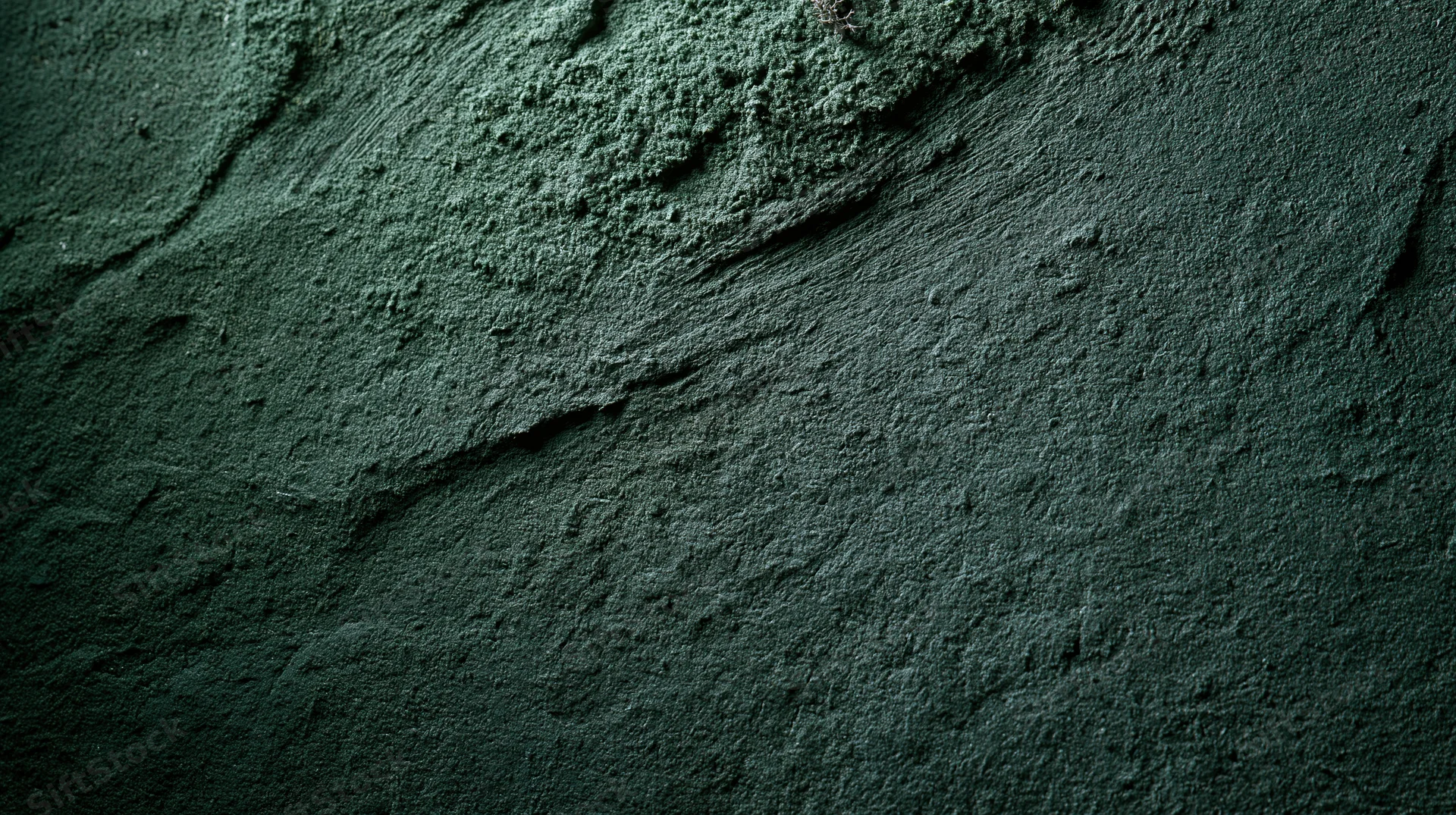 Close-up of rough textured concrete wall surface with cracks and shadows