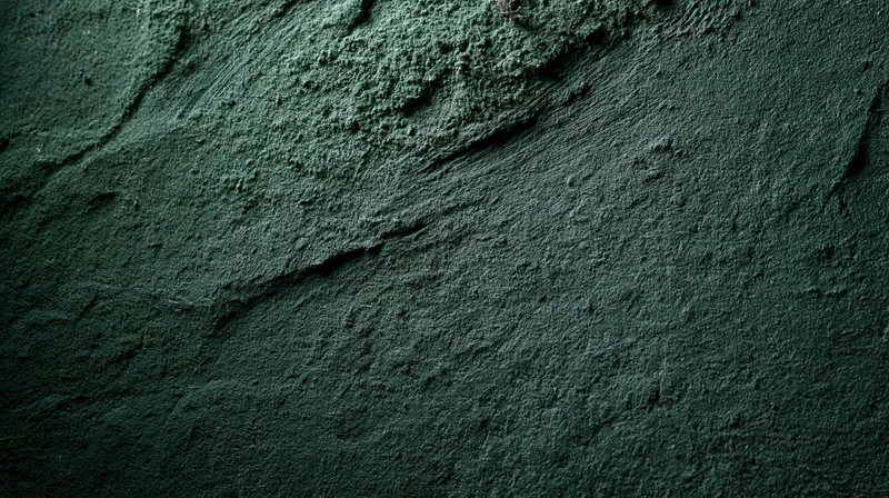 Close-up of rough textured concrete wall surface with cracks and shadows