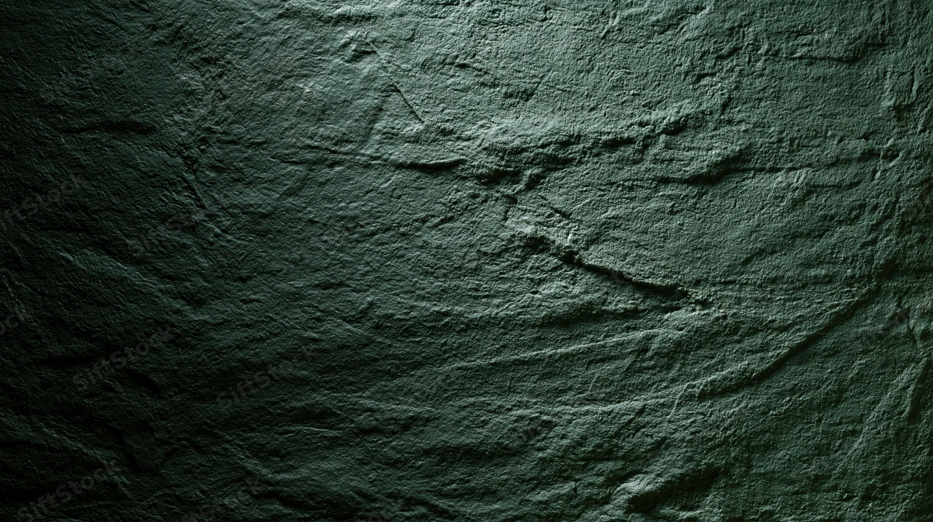 Close-up of rough textured concrete wall surface with dark gray tones and subtle lighting variations