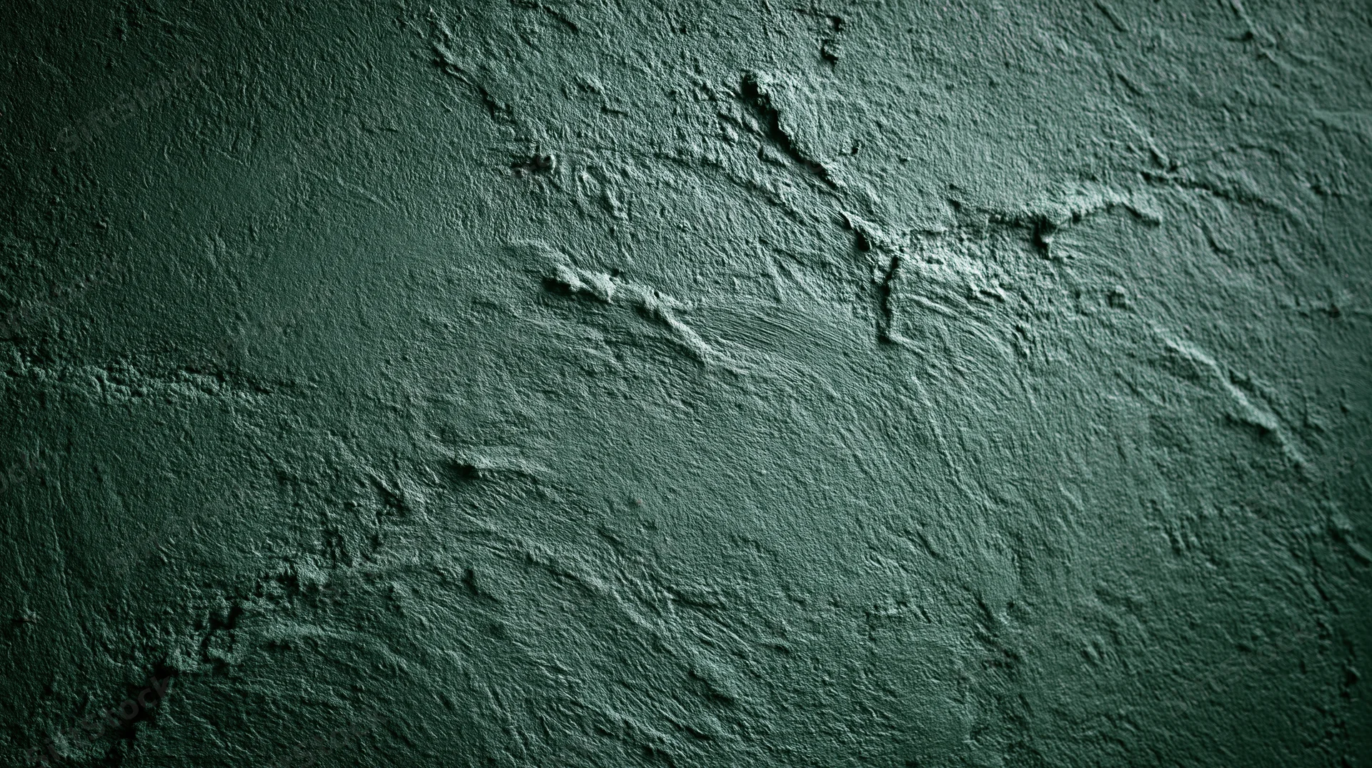 Close-up of rough textured concrete wall surface with dark green tones and visible cracks
