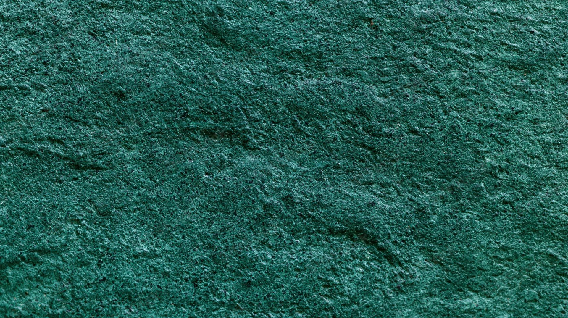Close-up of weathered dark green painted concrete surface