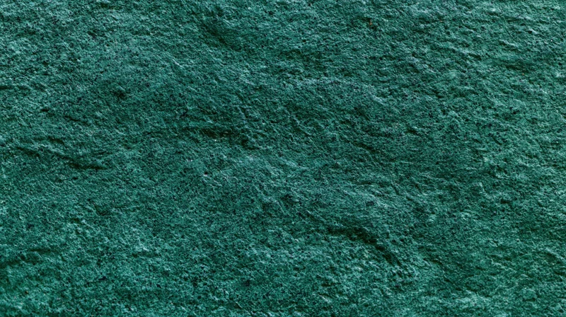 Close-up of weathered dark green painted concrete surface