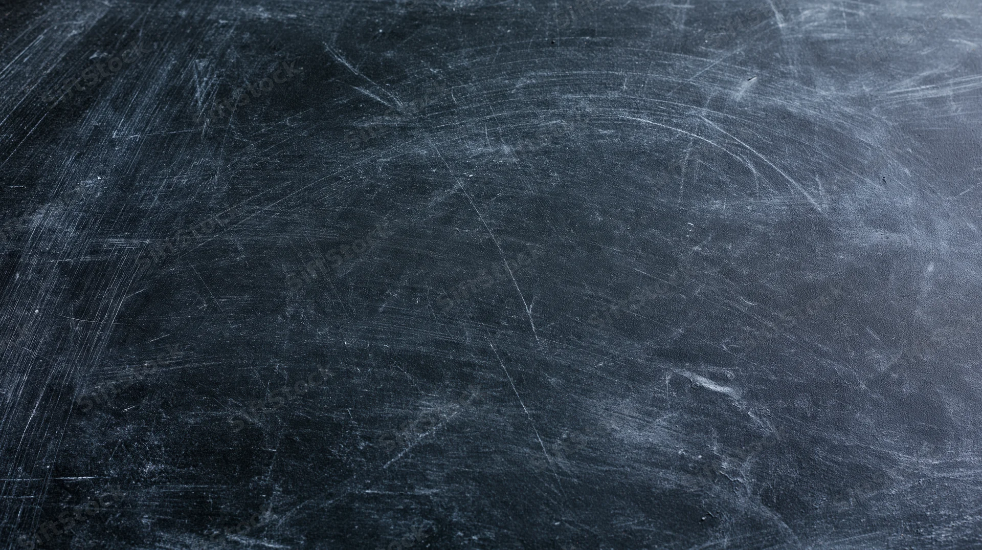 Close-up of a worn blackboard surface covered in chalk residue and scratches