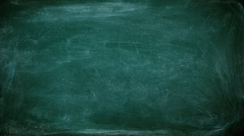Close-up of a worn dark green chalkboard surface with smudged chalk marks and scratches